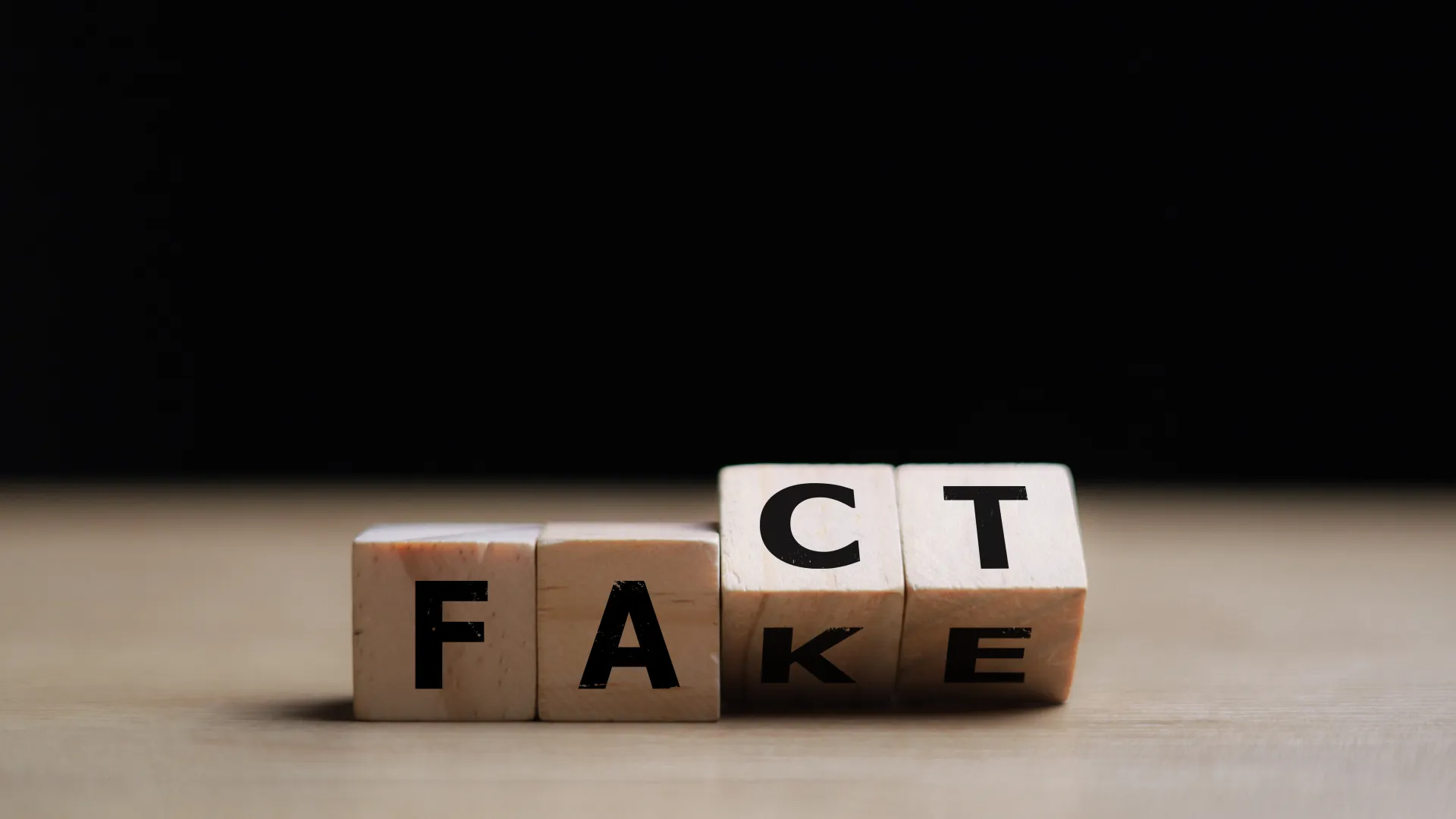 Vier Würfel, die Fact und Fake zeigen.